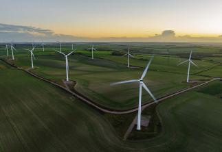 Wind Turbines In A Field with Sunset in background