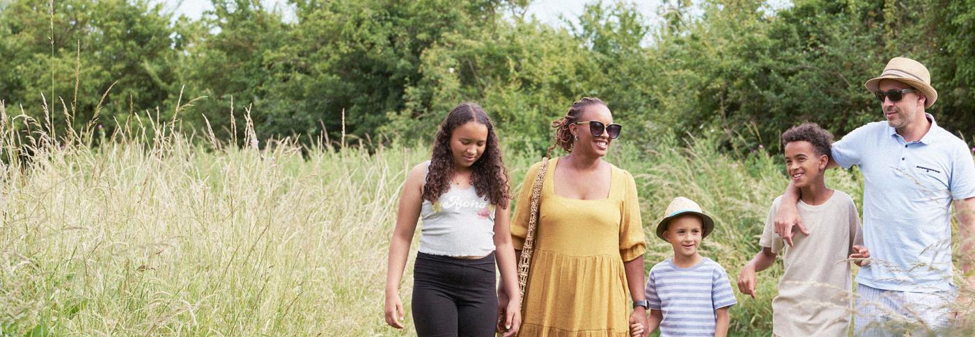 Family walking in summer outfits in a field