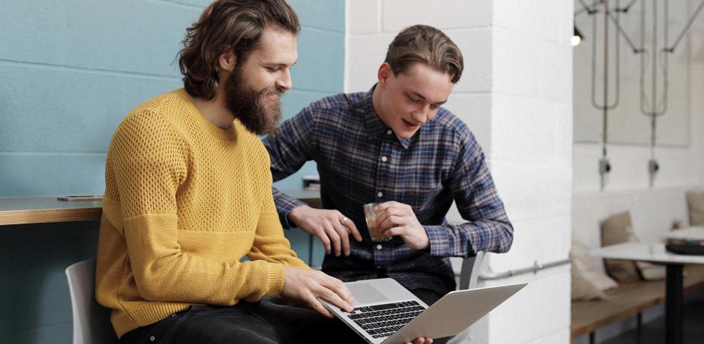 Two gentlemen working on a laptop together