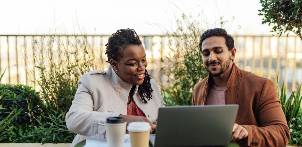 Two workers working together with coffee and laptop