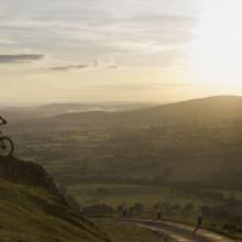 Cyclist on top of mountain with sunset