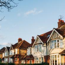 Image of houses with sun setting on them