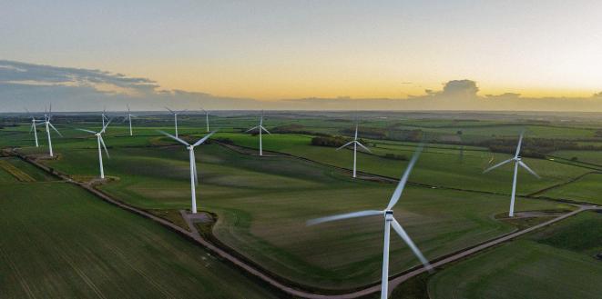 Wind Turbines In A Field with Sunset in background