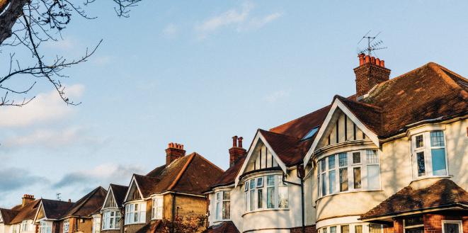 Image of houses with sun setting on them