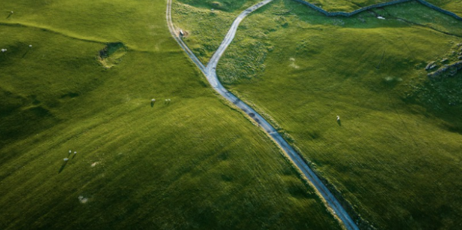 Single track country road through fields photo taken from above GettyImages-1486256079