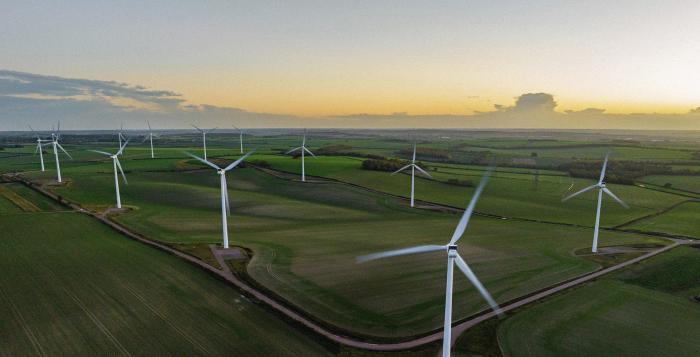 Wind Turbines In A Field with Sunset in background