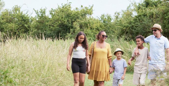 Family walking in summer outfits in a field